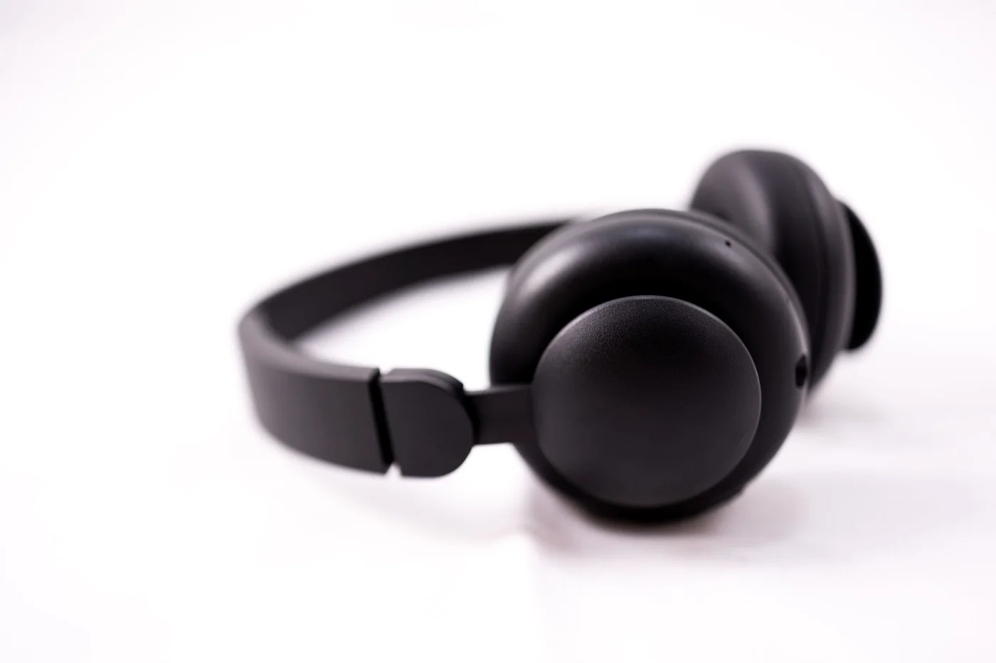 Matte black over-ear headphones on a white studio ground